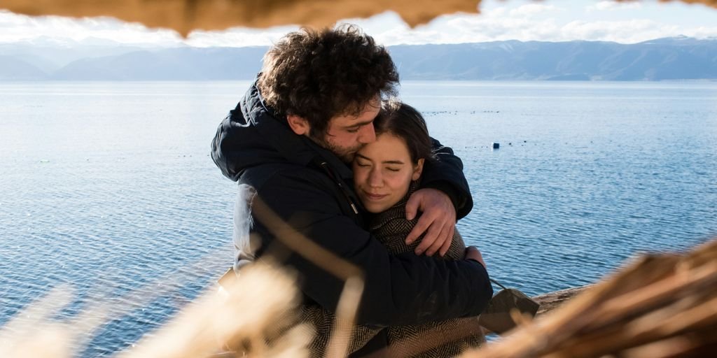 man and woman hugging each other near body of water during daytime