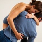 Couple in intimate captain sex position embrace.