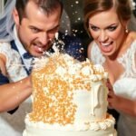 Bride and groom smash cake in each other's faces.